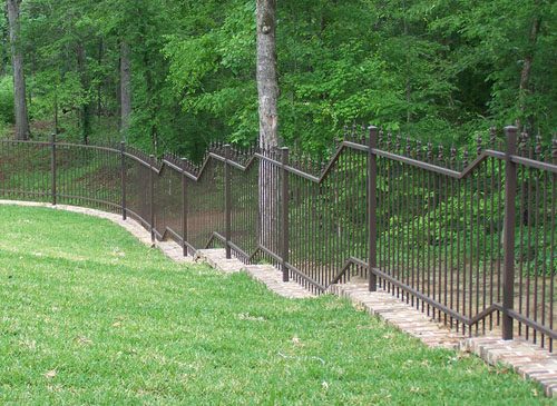 Different terrain calls for different fabrication and design techniques. This fence combines angular stair step design with a gentle curve at rear of yard. All in Weathered Brown Powder Coat.